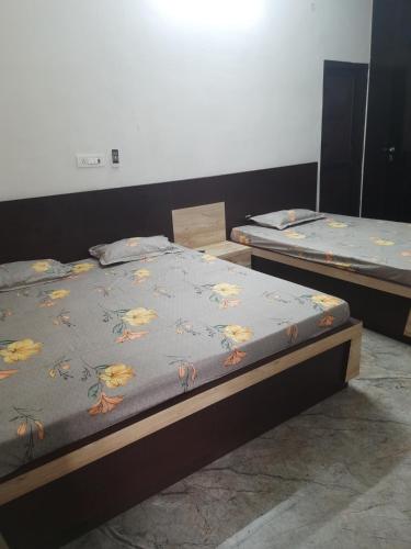 Dos camas individuales en una habitación con una colcha estampada con mariposas. en Shiv Villa, en Jaipur