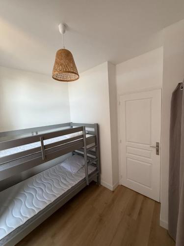 ラ・ロシェルにあるLe Rochelois by Maison ACGのランプとドアが付いた二段ベッドのある寝室