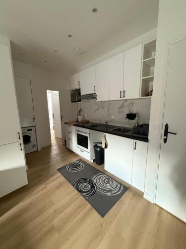 ラ・ロシェルにあるLe Rochelois by Maison ACGのキッチン(白いキャビネット、敷物付)