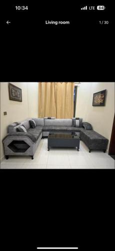 een woonkamer met een bank en een tafel bij Gill house in Multan