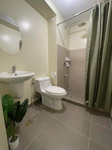a bathroom with a toilet and a sink and a shower at Stena Stays 219 in Kaybagal