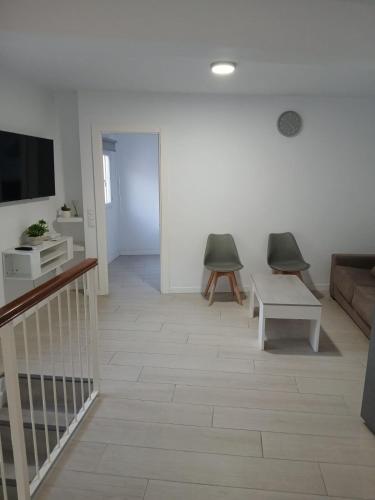 ein Wohnzimmer mit einem TV und 2 Stühlen in der Unterkunft Apt isabel in Ardales