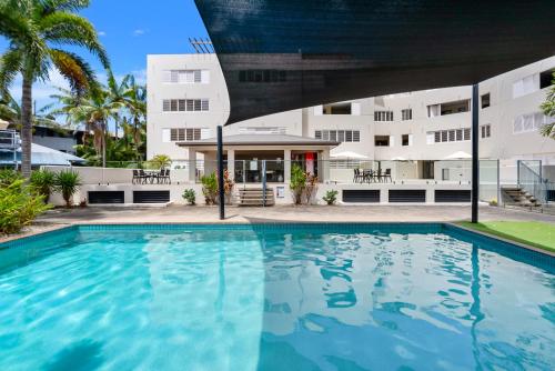 a swimming pool in front of a building at Allure at The Edge 3brm luxury apartment with coffee machine and 2 pools! in Cairns North