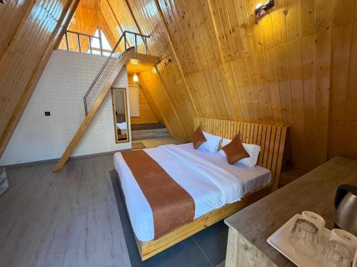 um quarto com uma cama em uma cabana de madeira em Muskan Mount View Retreat, Mukteshwar em Mukteswar