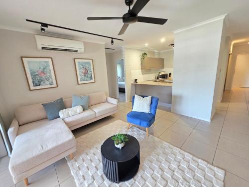 a living room with a couch and a blue chair at Allure at The Edge 3brm luxury apartment with coffee machine and 2 pools! in Cairns North