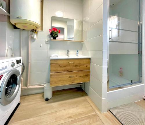 a bathroom with a sink and a washing machine at MaisonTevy - Appart 2 Chambres-4lits-Terrasse-Jardin & Studio-Confort-Climatisation- Idéale-Pro-Tourisme in Pontault-Combault