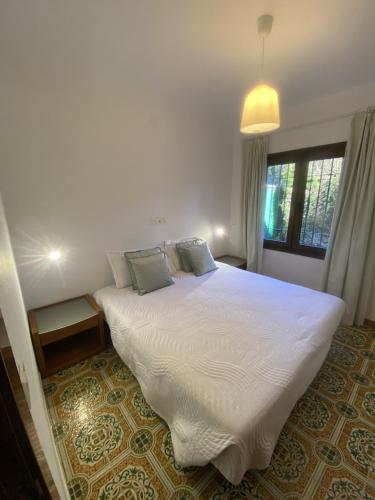 una camera da letto con un grande letto bianco e una finestra di Villa CASTILLA a Cambrils