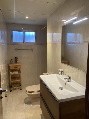 un bagno con lavandino, WC e specchio di Villa CASTILLA a Cambrils