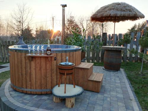 Folwark Kuźniaki-Agroturystyka i Konie, Gorąca Bania في Strawczyn: حوض استحمام ساخن مع بار ومظلة