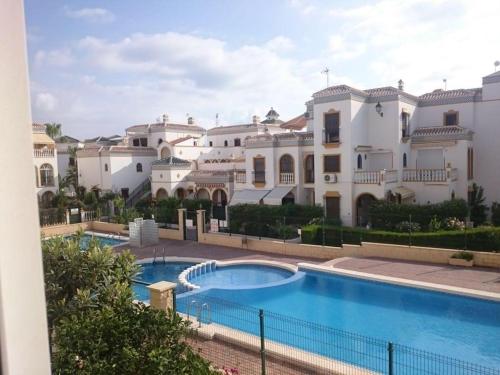 a large house with a swimming pool in front of it at Sonne, Strand und Urlaubsmodus! in Torrevieja