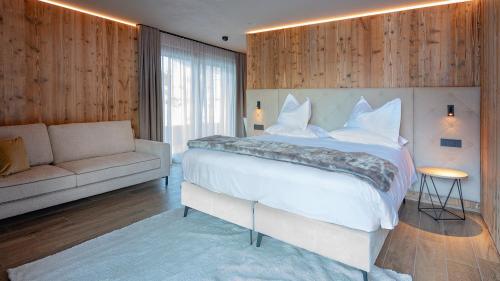 a bedroom with a large white bed and a couch at Paradise Lodge in Livigno