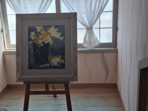un quadro su un piedistallo davanti a una finestra di Capri Hakdong Pension a Geoje