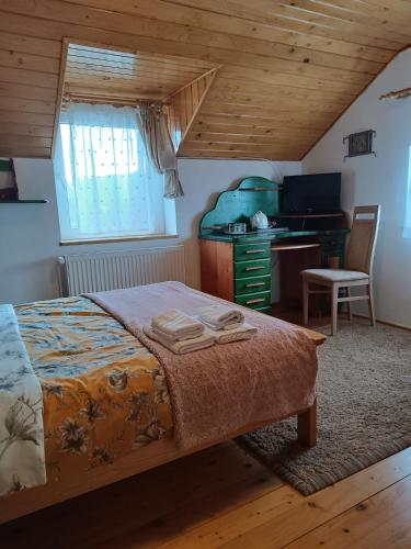 a bedroom with a bed and a desk in a room at Casa din Prund din Porumbacu de sus in Porumbacu de Sus