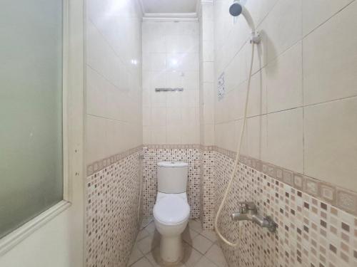 un baño con inodoro y ducha en Tamastu Hotel Fortuna Jatiwaringin, en Pangkalan