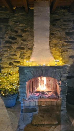 a stone fireplace with a fire inside of it at Chalet coeur d'alpage La Plagne Les Arcs in La Plagne Tarentaise