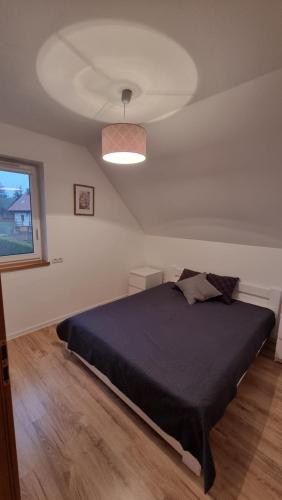 ein Schlafzimmer mit einem großen Bett und einer Decke in der Unterkunft Moje Mazury Wilk in Wilnowo