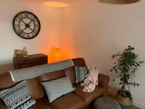 a living room with a couch and a clock on the wall at Cartref 2 Double Bed Apartment Nebo Dogs Welcome in Amlwch
