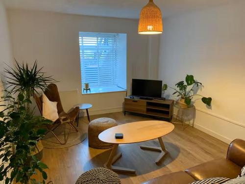 a living room with a table and chairs and a television at Cartref 2 Double Bed Apartment Nebo Dogs Welcome in Amlwch