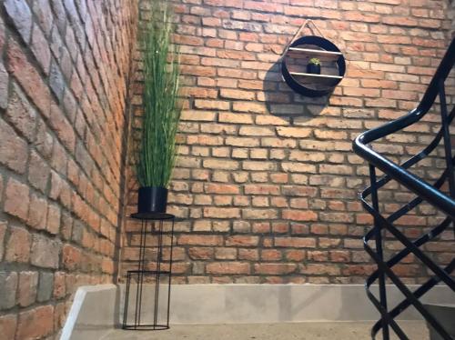 un muro di mattoni con una pianta in vaso su un supporto di Apartament Gór-SKI a Malinka
