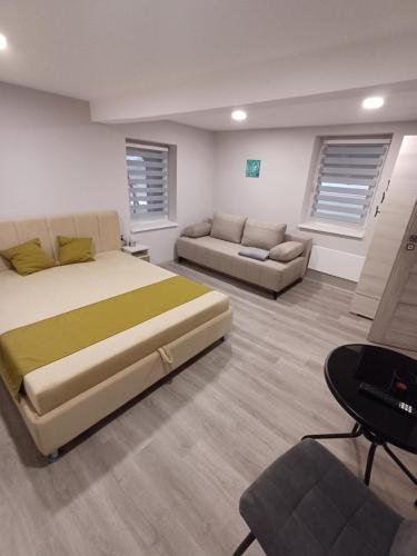 a bedroom with a large bed and a couch at Borka-land Vendégház in Deszk