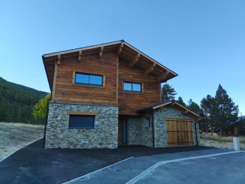 a house with a wooden roof and a garage at Chalet Prestige - Ski au pieds - Les Angles in Les Angles