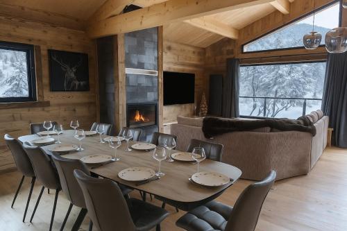 a dining room with a table and chairs and a fireplace at Chalet Prestige - Ski au pieds - Les Angles in Les Angles