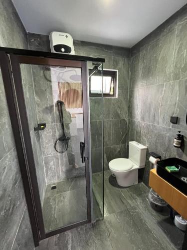a bathroom with a shower and a toilet in it at Kali Code Home in Yogyakarta