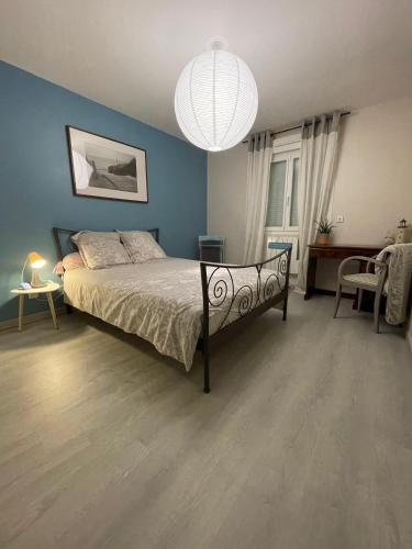 Un dormitorio con una cama y una pared azul. en Chambre cosy entre ville et campagne, en Lorette
