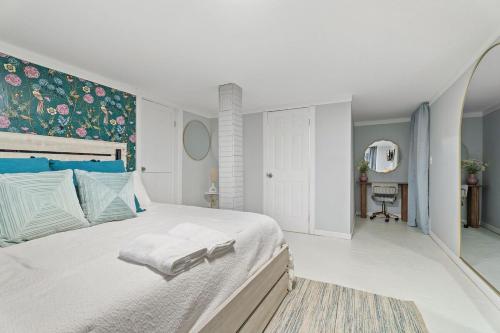 Near Ithaca! Hot Tub! LRG Home! Sleeps 10 Dogs ok! في Newfield: غرفة نوم بيضاء مع سرير كبير مع اللوح الأمامي الأزرق