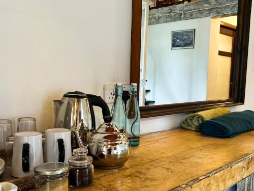 Rowinrich Cottages في إيلا: سطح عمل مع غلاية شاي ومرآة