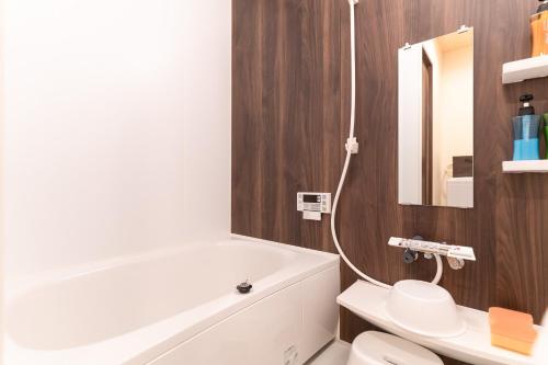 a bathroom with a white tub and a toilet at 蛮子民宿 金閣寺 in Kyoto