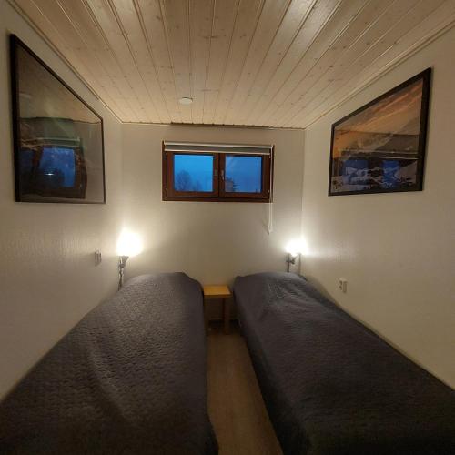 a small room with two beds and two windows at Tahkonloft in Tahkovuori