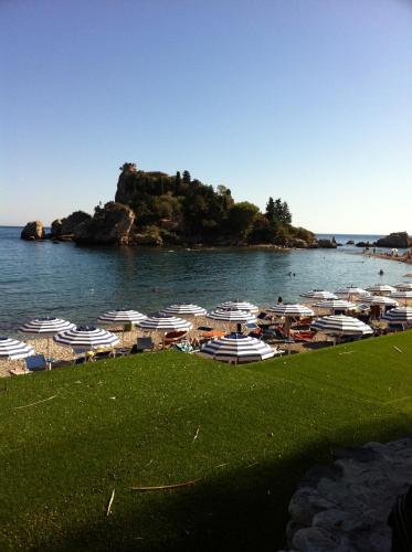 a beach with umbrellas and a bunch of boats at ToviMar Apartments in Taormina