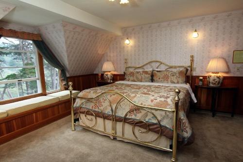 a bedroom with a bed and two windows at Elk Cove Inn & Spa in Elk