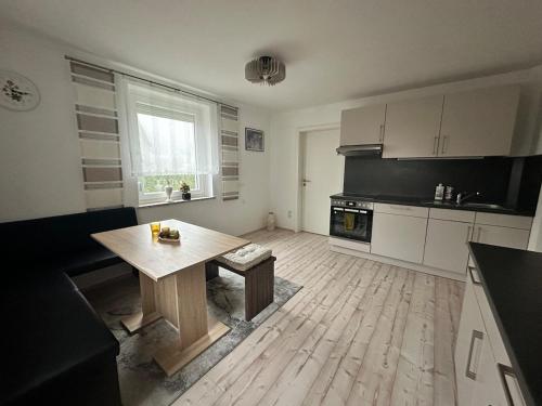 Steinbach am WaldApartment Lale的厨房中间设有木桌