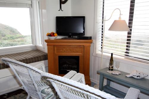 a living room with a television and a table and chairs at Elk Cove Inn & Spa in Elk
