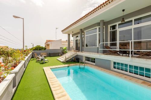 a backyard with a swimming pool and a house at Escape To your Private Pool, Sea Views and Bbq in Jinámar