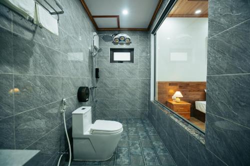 Un baño con inodoro blanco y ducha. en Tràng An Riverbank Homestay, en Nguyên Ngoại