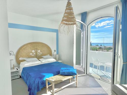 a bedroom with a blue bed and a balcony at Salento astrea vista mare in Porto Cesareo