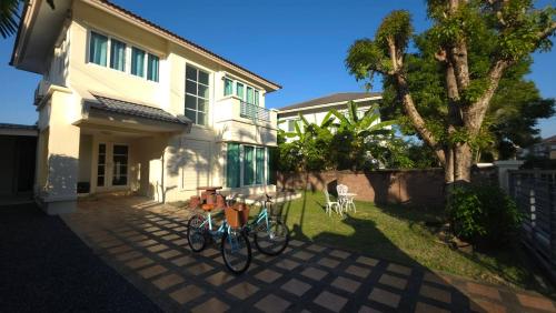 two bikes parked in front of a house at Pailin Hill At Casa Ville Watcharapol in Bangkok