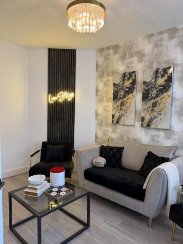 a living room with a couch and a table at Lux 4 Bedroom House - Jacuzzi Bath Sleeps 9 Free Parking Near Leeds Centre in Leeds