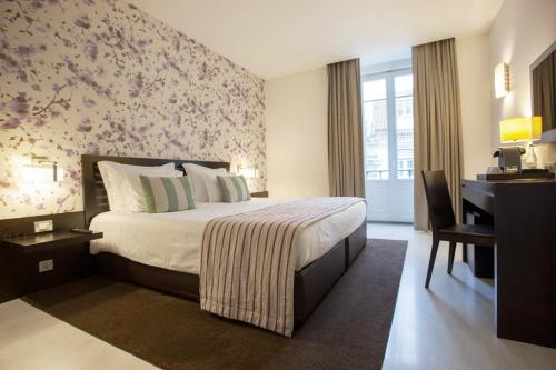a bedroom with a large bed with a floral wall at Internacional Design Hotel in Lisbon