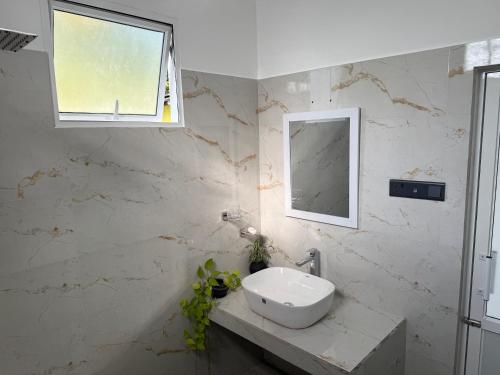 a white bathroom with a sink and a window at Seaview Mountain Villa in Mirissa