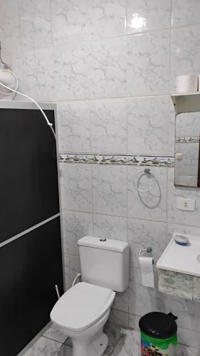a white bathroom with a toilet and a sink at Enumo House in Itapoa