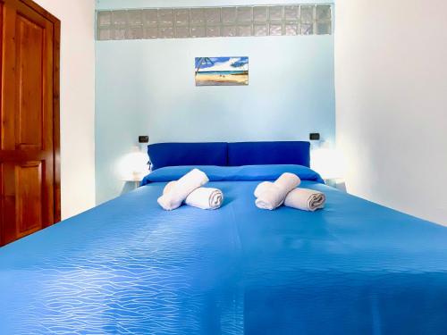 a blue bed with two white pillows on it at Casa Francesco Seaside in Sant'Angelo D'Ischia