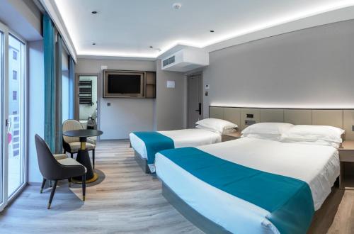 ein Hotelzimmer mit zwei Betten und einem Fernseher in der Unterkunft Hotel Calagurris in Calahorra