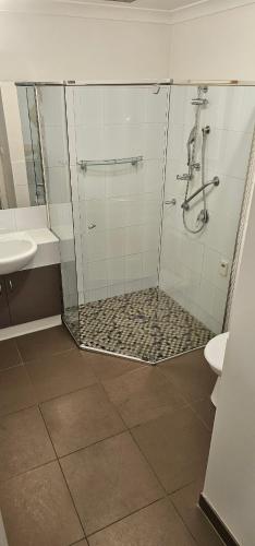 a bathroom with a shower and a toilet and a sink at Star on Main with a Pool in Lower Plenty