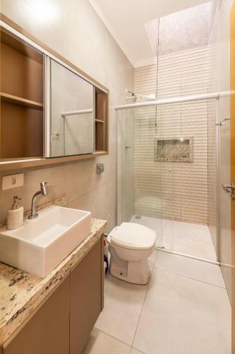 a bathroom with a sink and a toilet and a shower at Casa Munique Maringa Com Piscina Ar Condicionado e Churrasqueira in Maringá