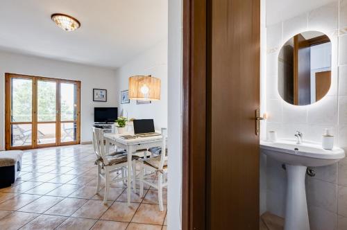 a bathroom with a sink and a table with a laptop at Appartamento vista mare, 100mt dall'Ospedale Pediatrico, a 200mt dal mare, 1h da Roma Termini in Santa Marinella