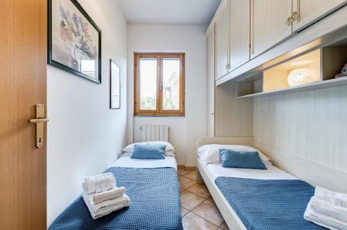 two beds in a small room with a window at Appartamento vista mare, 100mt dall'Ospedale Pediatrico, a 200mt dal mare, 1h da Roma Termini in Santa Marinella